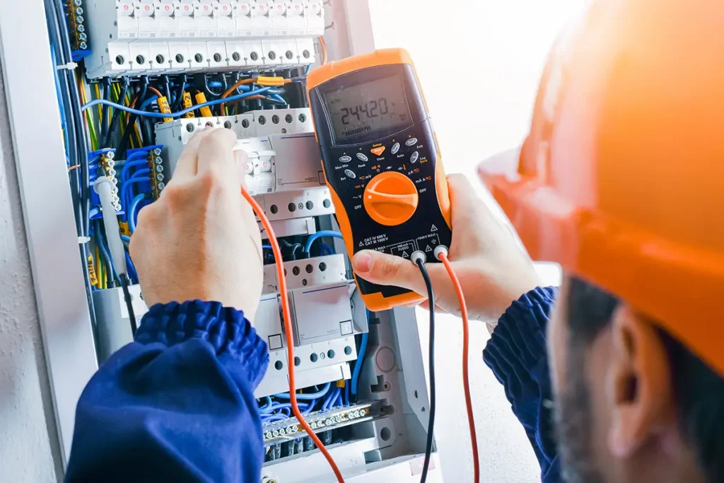 Electrician using a multimeter to troubleshoot and test an electrical panel for repairs.